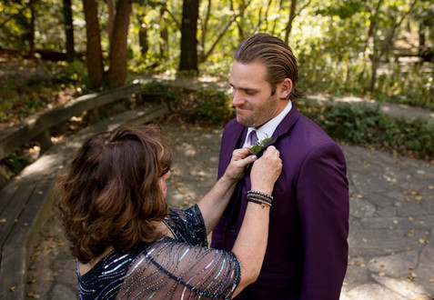 bride's mom fixing up the groom's suit