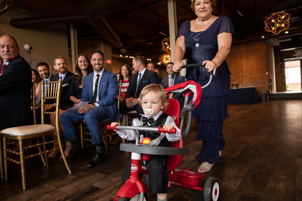 ring bearer riding a bike down the aisle