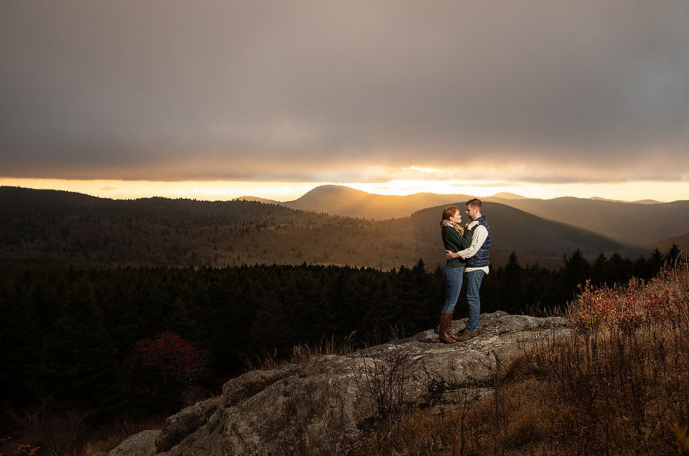 dramatic lighting portrait of a couple holding each other in front of the mountains