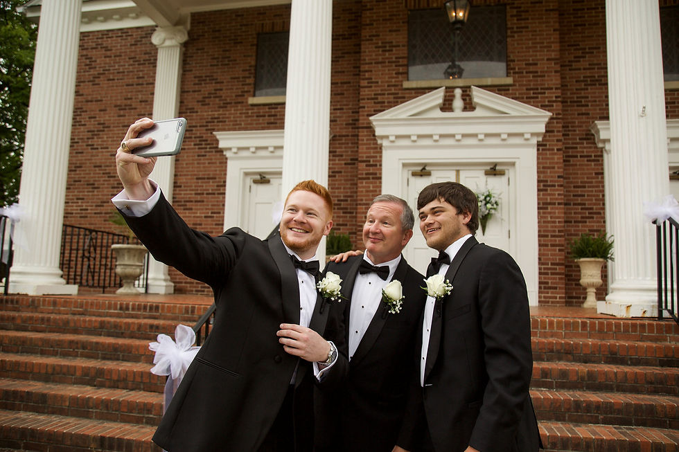 groom taking a selfie with his dad and brother