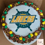 An 8-inch chocolate graduation cake with an edible image of SUNY Oswego's logo, the Lakers for hockey or lacrosse player.
