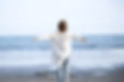 Woman taking deep breaths and stretching on sandy beach Stress free.jpg