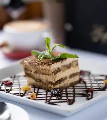 Classic Italian tiramisu dessert served in Melbourne restaurant with chocolate drizzle and coffee