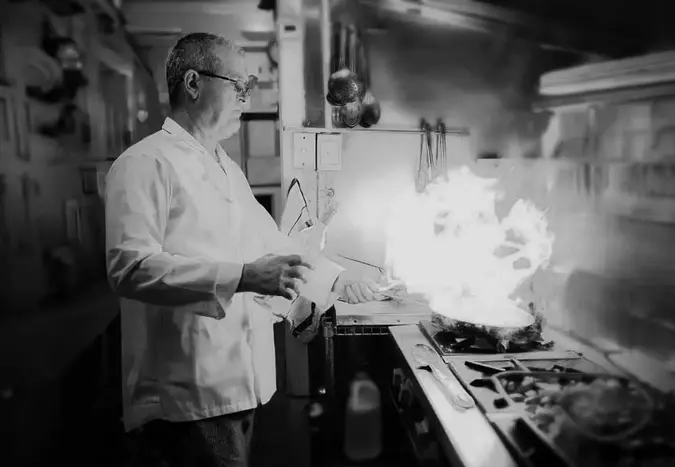 Italian chef cooking in restaurant kitchen in Melbourne showcasing traditional techniques