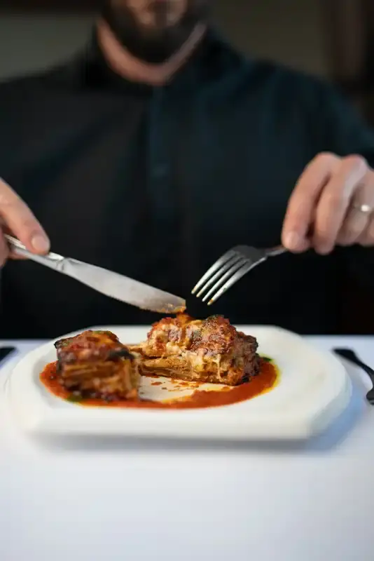 Italian lasagna being served in Melbourne restaurant with rich sauce and melted cheese