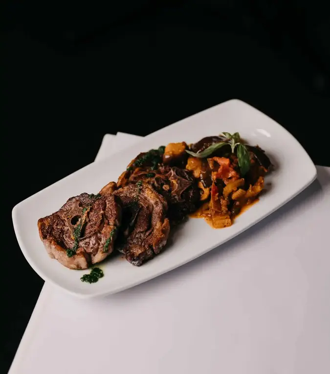 Italian meat dish served in Melbourne restaurant with roasted vegetables and rich flavours