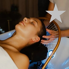 eine Frau, die auf einer Liege liegt und eine entspannende Haardusche mit Massage genießt