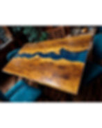 Mesa de madeira escura com resina azul brilhante no meio, cadeiras azuis ao redor