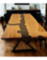 mesa de jantar de madeira clara com resina preta no meio cadeiras ao redor