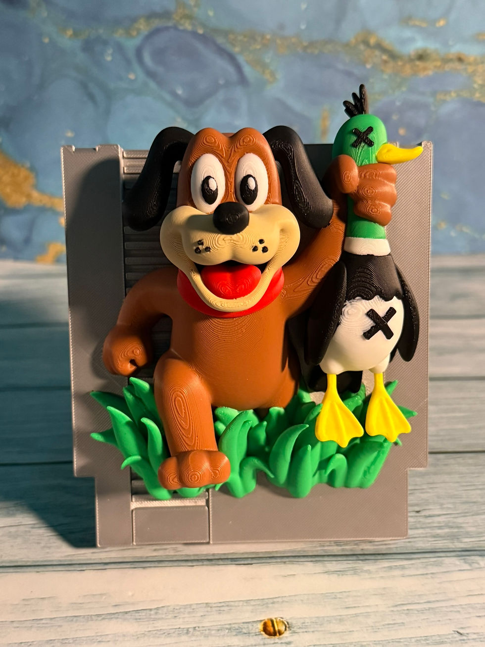 Thumbnail: 3D printed retro hunting dog holding a duck in a colorful classic gaming-inspired display, approximately 6.5 inches tall by 5