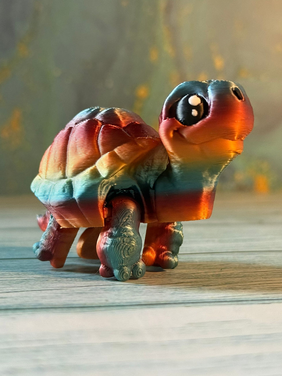 Thumbnail: Small colorful 3D printed turtle on a wooden surface.
