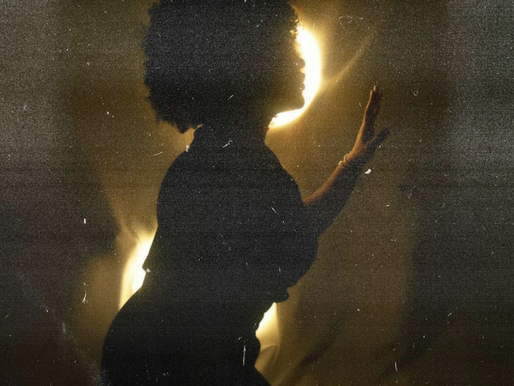 Arte por Coralis Cruz González. Mujer negra con pelo afro en frente de una luz amarilla.