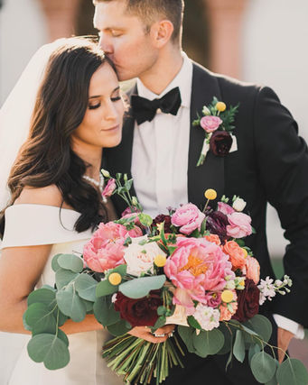 Bride and groom with lush bouquet of pink peonies, garden roses, and eucalyptus. Chicago wedding florist.