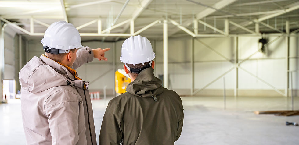 Twee FONS. bouwmanagers controleren de voortgang van een bedrijfspand op de bouwplaats.