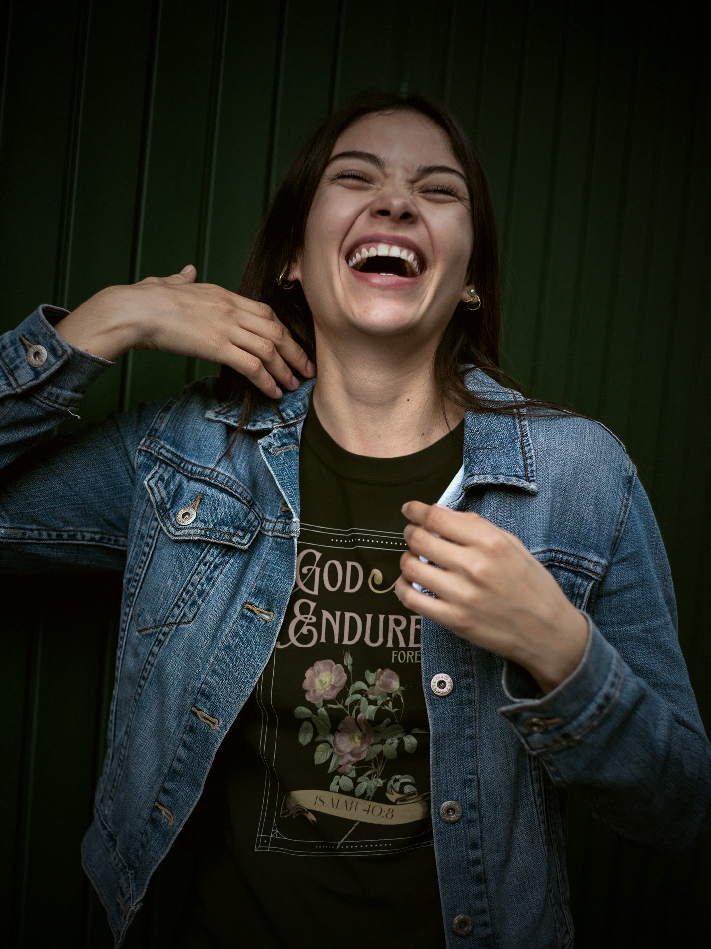 Laughing woman in a denim jacket wearing the God Endures Isaiah 40:8 tee