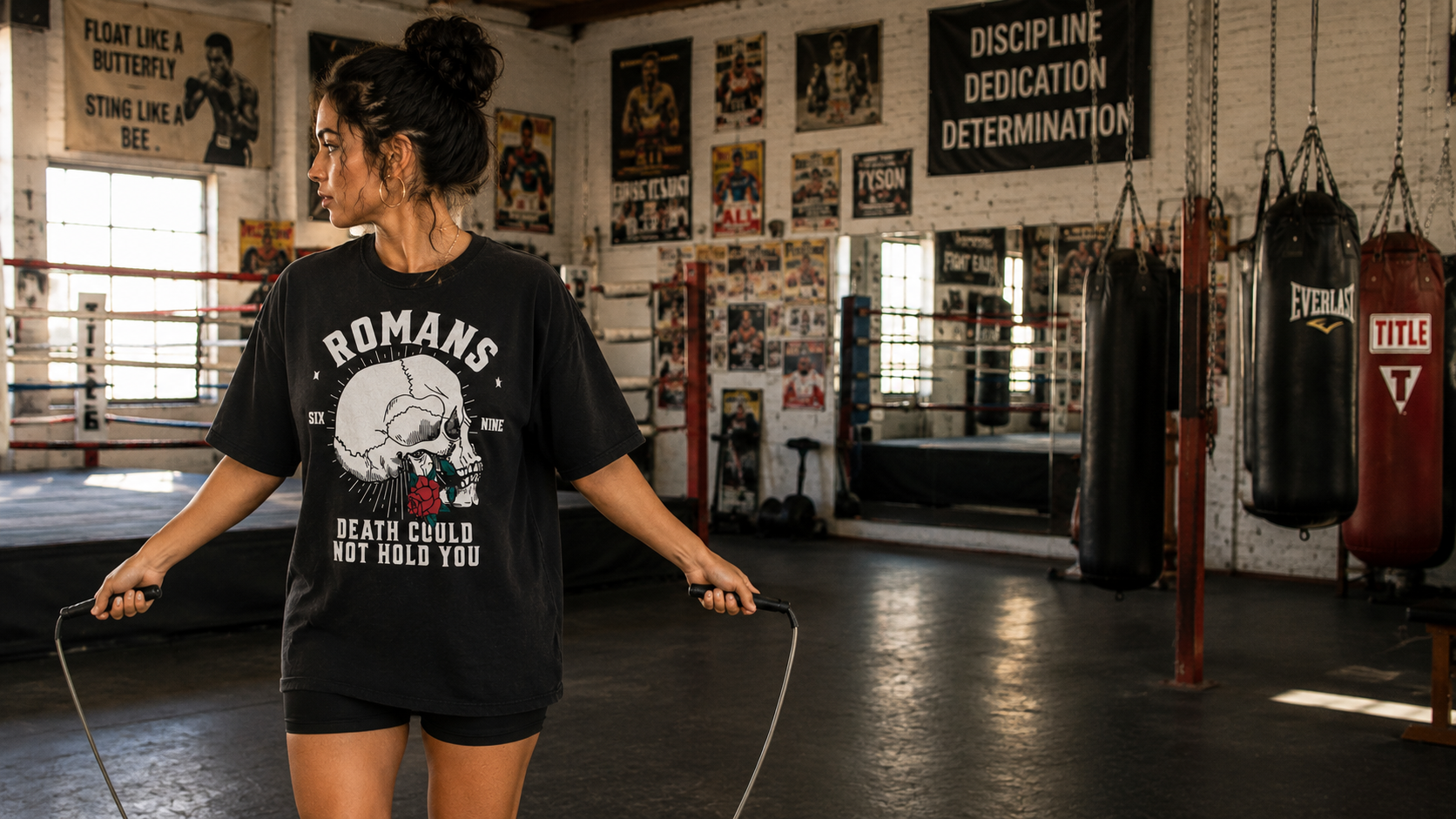 Woman in the Romans 6:9 Death Could Not Hold tee jumping rope in a boxing gym