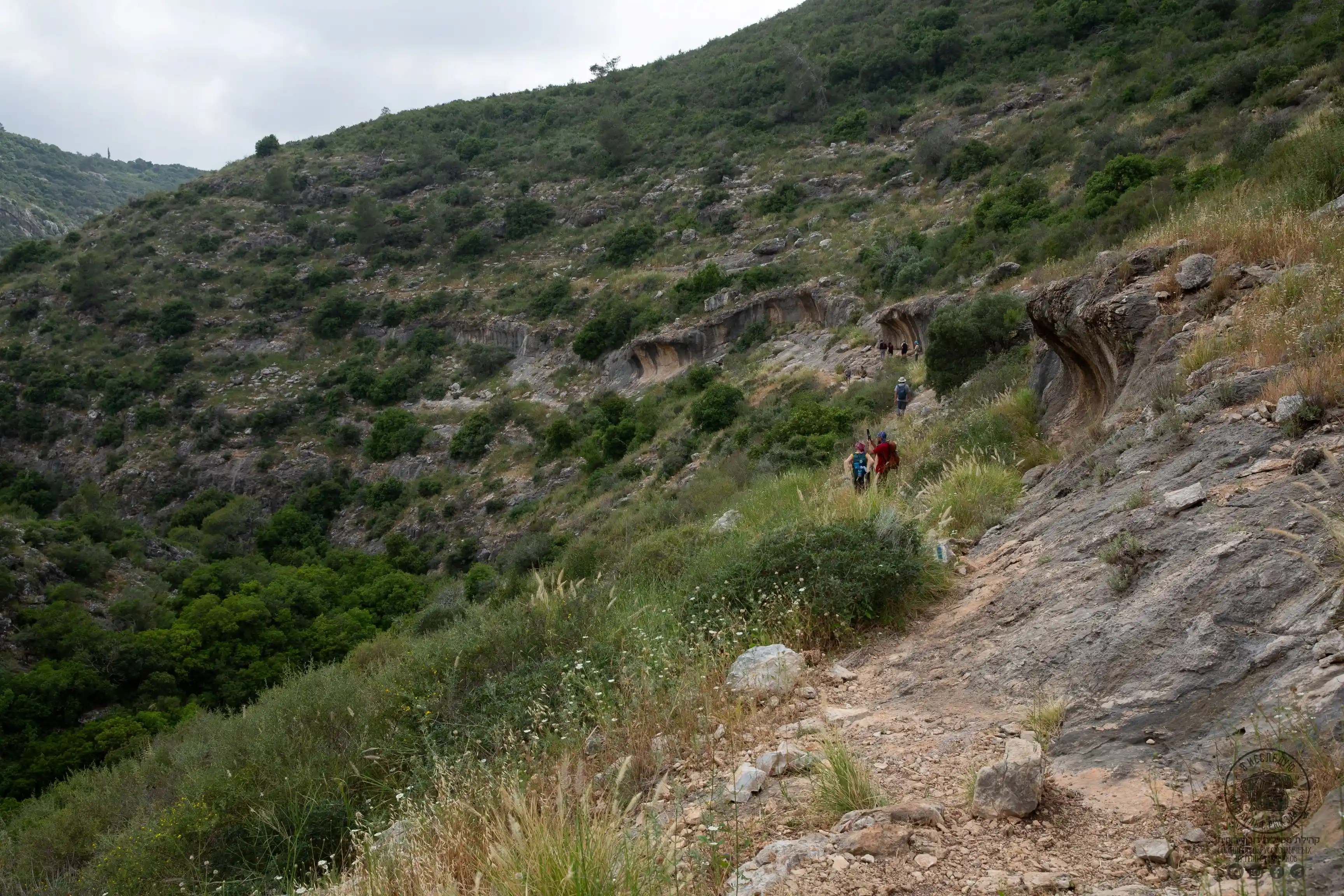 туристы вдалеке на тропинке у скал