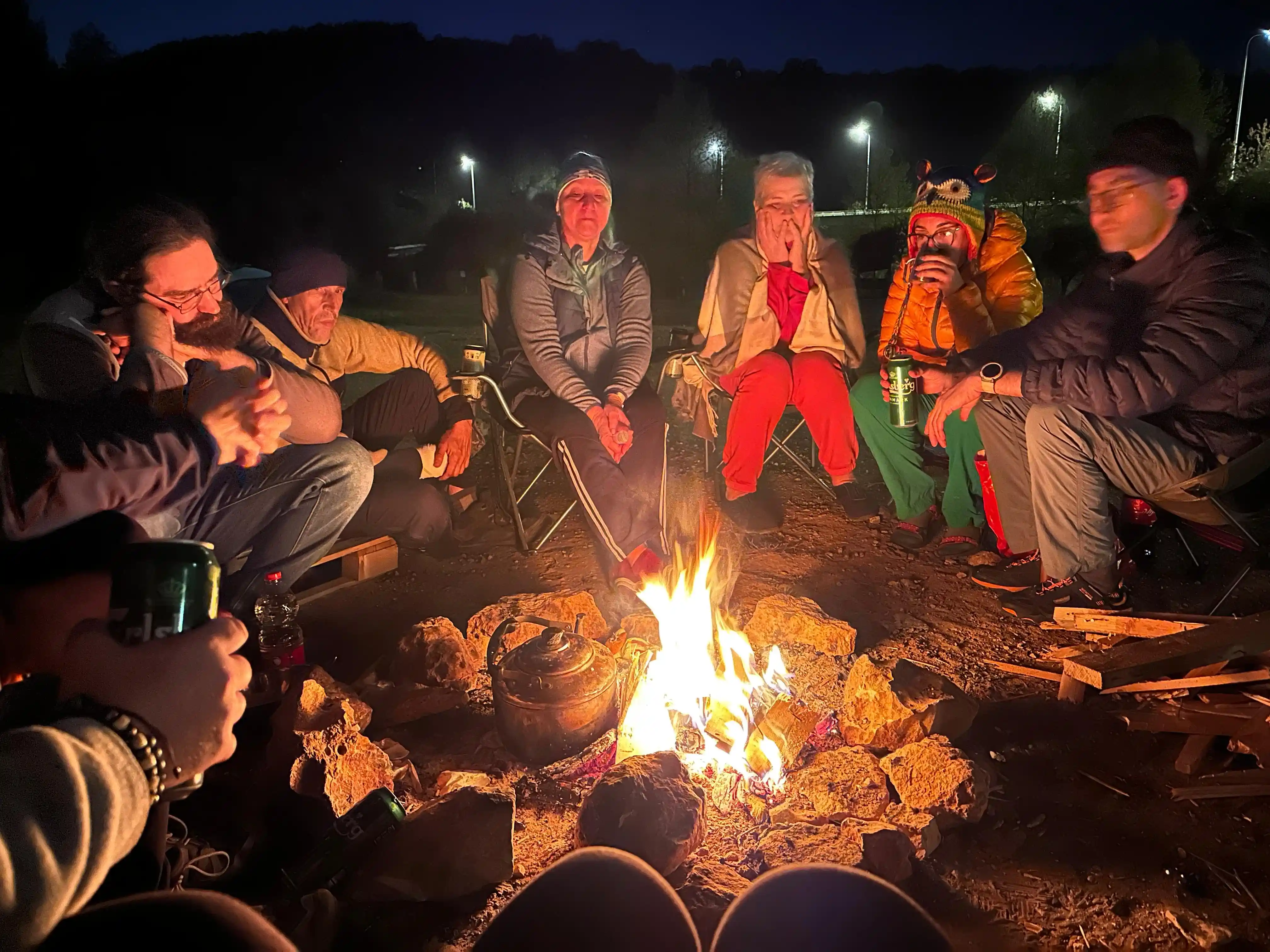 туристы сидят у костра ночью