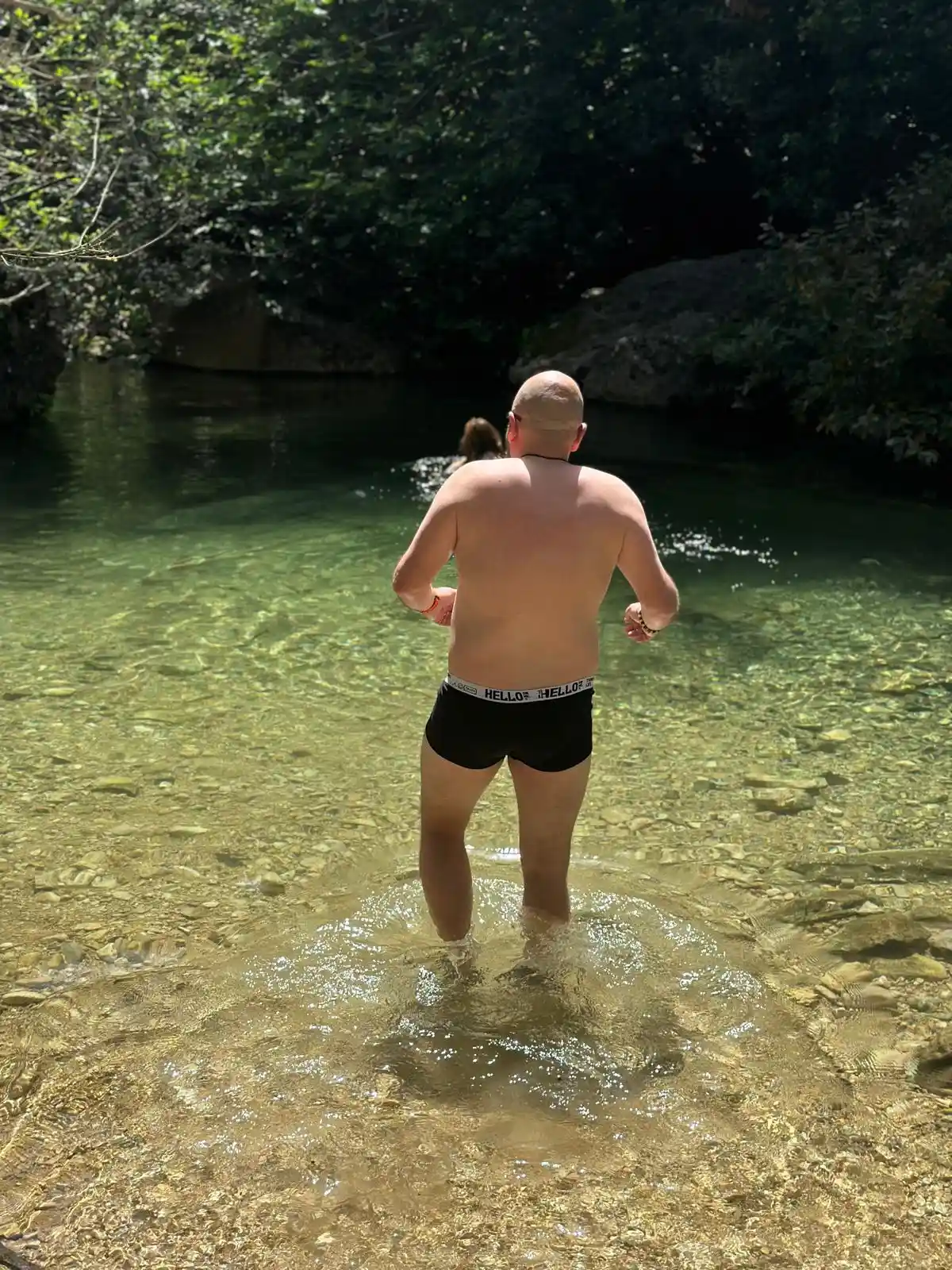 мужчина в трусах заходит в источник