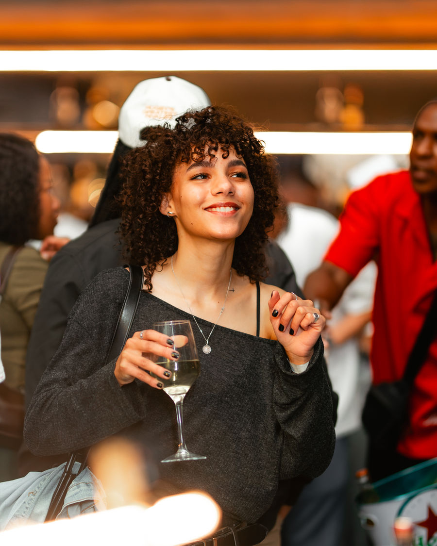 A guest smiling with a glass of wine at Winehouse