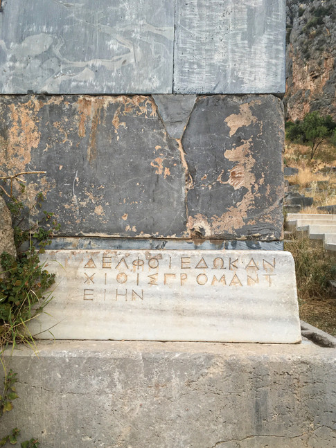 A close-up of the bricks of the Athenian Treasury in Delphi, Greece, one with carved inscriptions of Ancient Greek