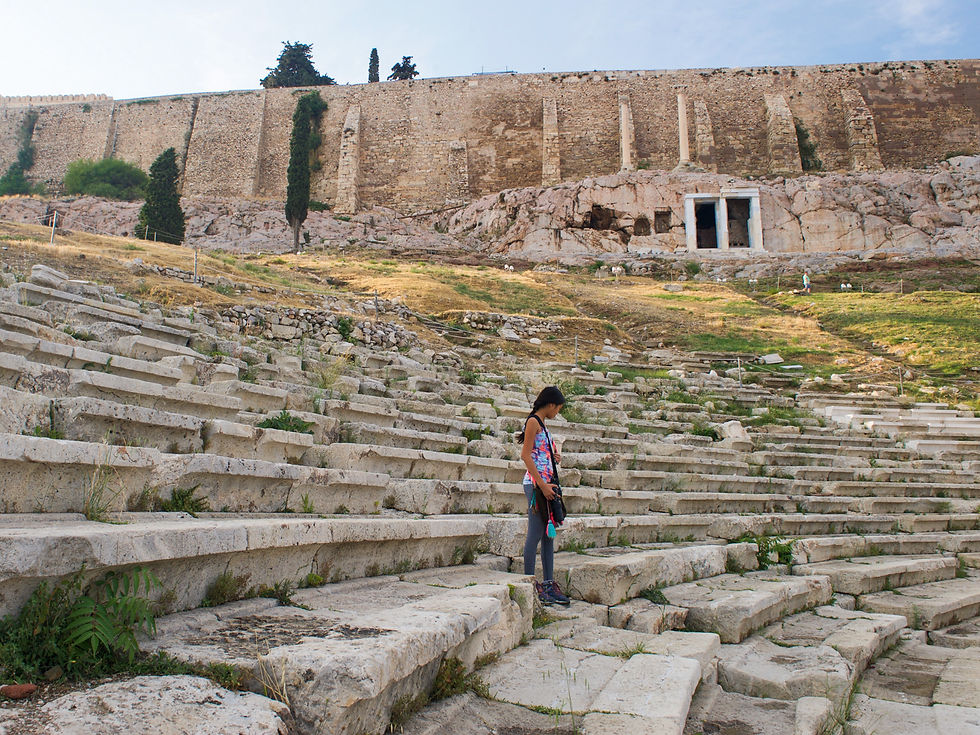 Eryn standing among the seats of the Theater of Dionysus below the wall of the Acropolis of Athens