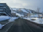 A paved road leading towards the snow-covered ski slopes of Grand Hirafu in Niseko, Japan