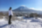 Eryn looks out to the buildings in the main town of Hirafu backdropped by a snowcapped Mount Yotei in Niseko, Japan