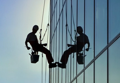 single worker on rope access cleaning windows