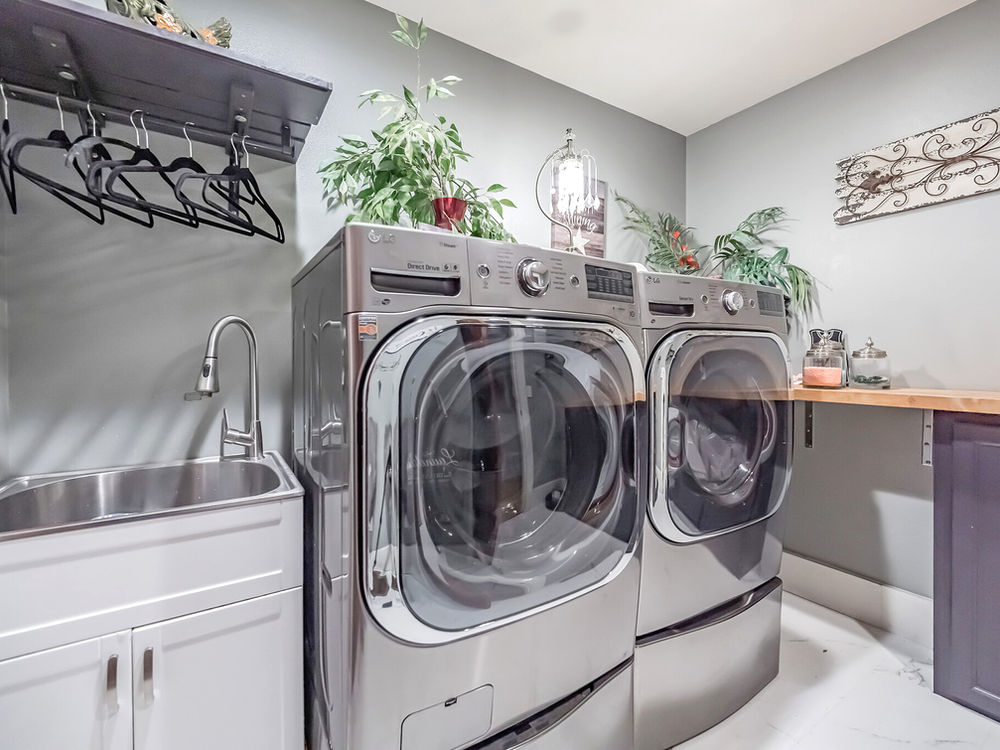 On-site laundry at The Grayson — full-size washer and dryer with a utility sink