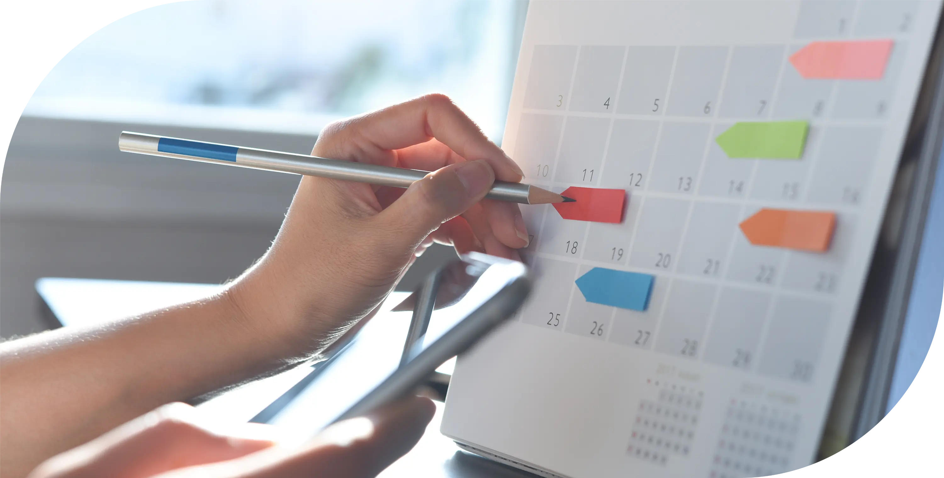 A person using a pencil on a calendar.