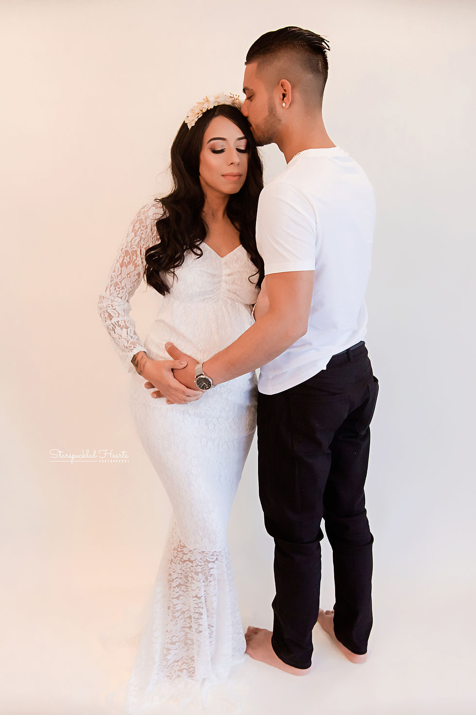 beautiful pregnant mum wearing a lacy white dress and her husband for their bump to baby maternity session in hampshire and berkshire