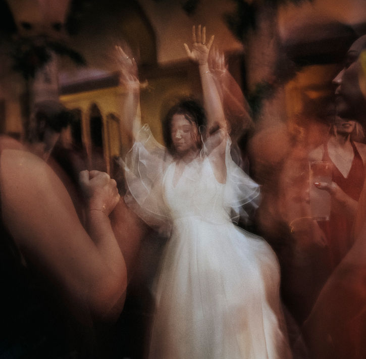 Manos entrelazadas de los novios en movimiento durante la fiesta.