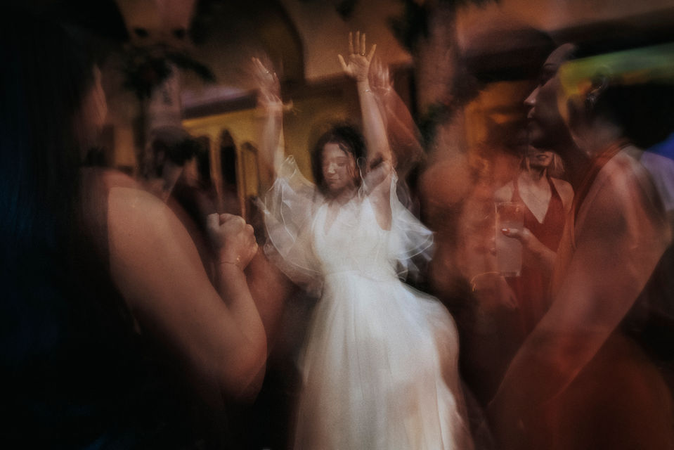 Manos entrelazadas de los novios en movimiento durante la fiesta.