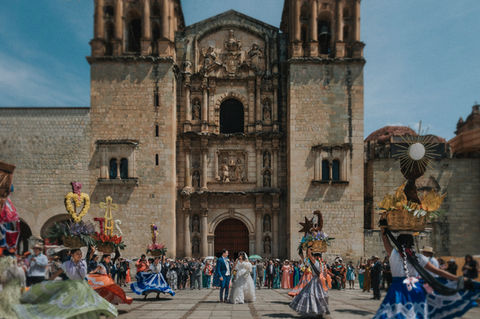 Novios besándose frente a iglesia barroca en ciudad histórica de México.