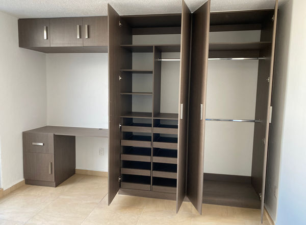 Clóset con puertas abiertas mostrando entrepaños y zapatera