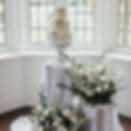 Bridies Cakes wedding cake on a display plinth with drapes and flowers