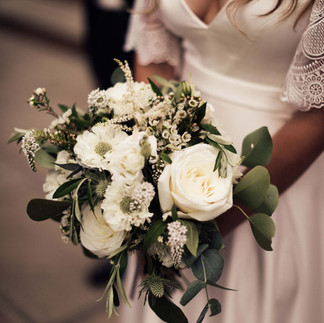 Bride holding a bouquet with white flowers and eucalyptus