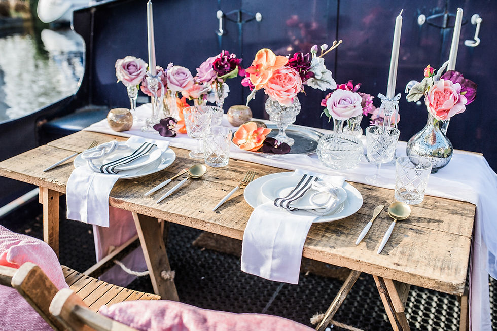Nautical themed sweetheart table with crystal bud vases and candlesticks, modern gold and white cutlery and white linen.