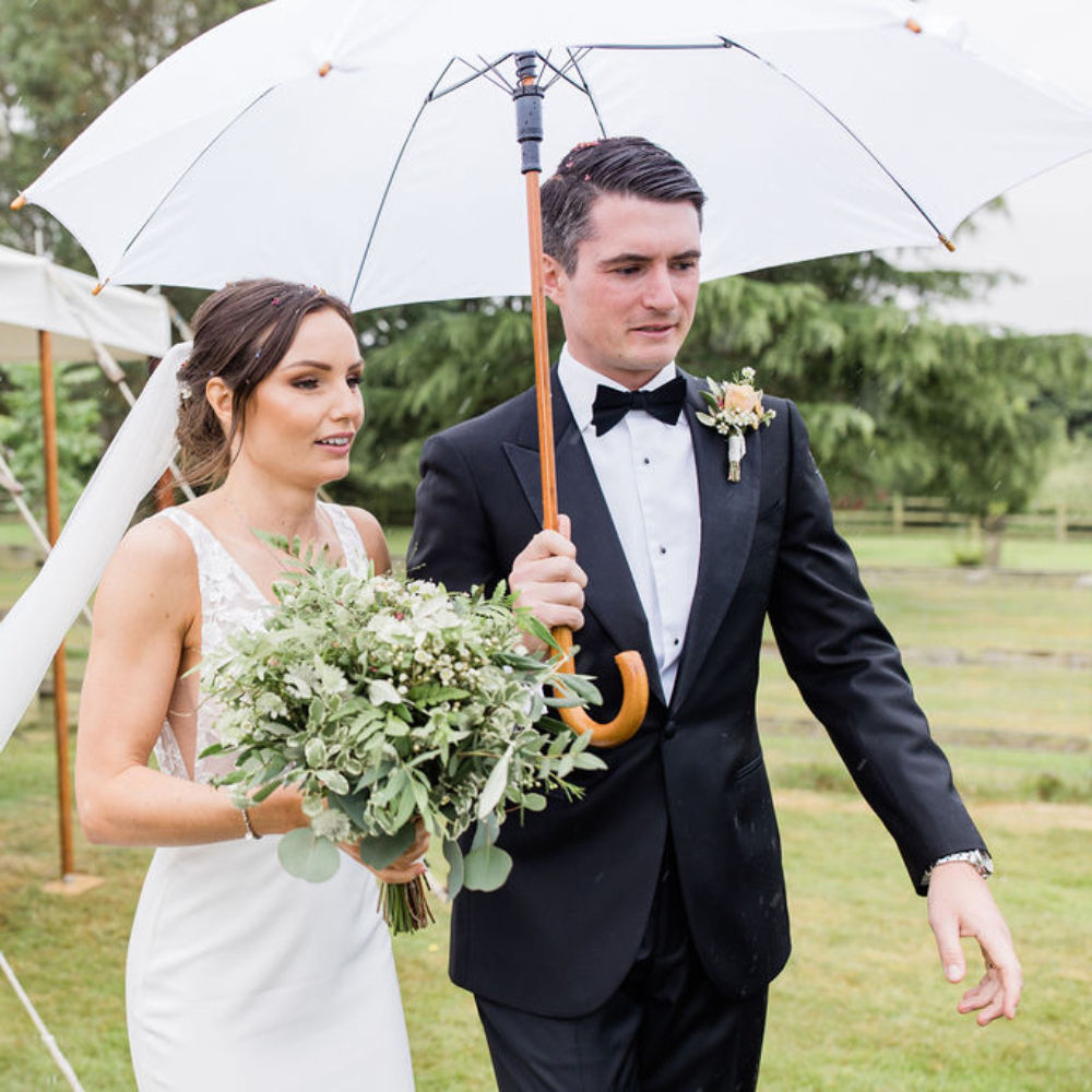 Bride and groom under wedding umbrella