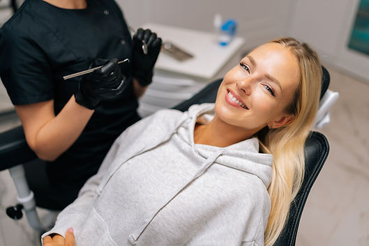 Woman smiling in dental chair with dentist sat beside her