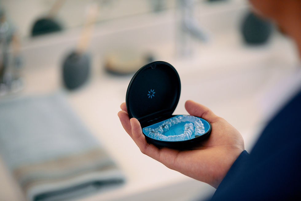 Invisalign clear aligners placed in their open case, which is being held by a patient