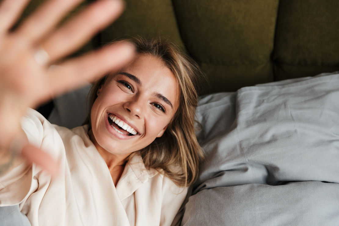 Person smiling reaching for camera
