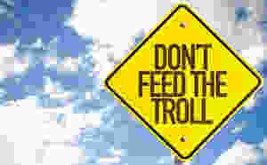 Don't Feed the Troll sign with sky background
