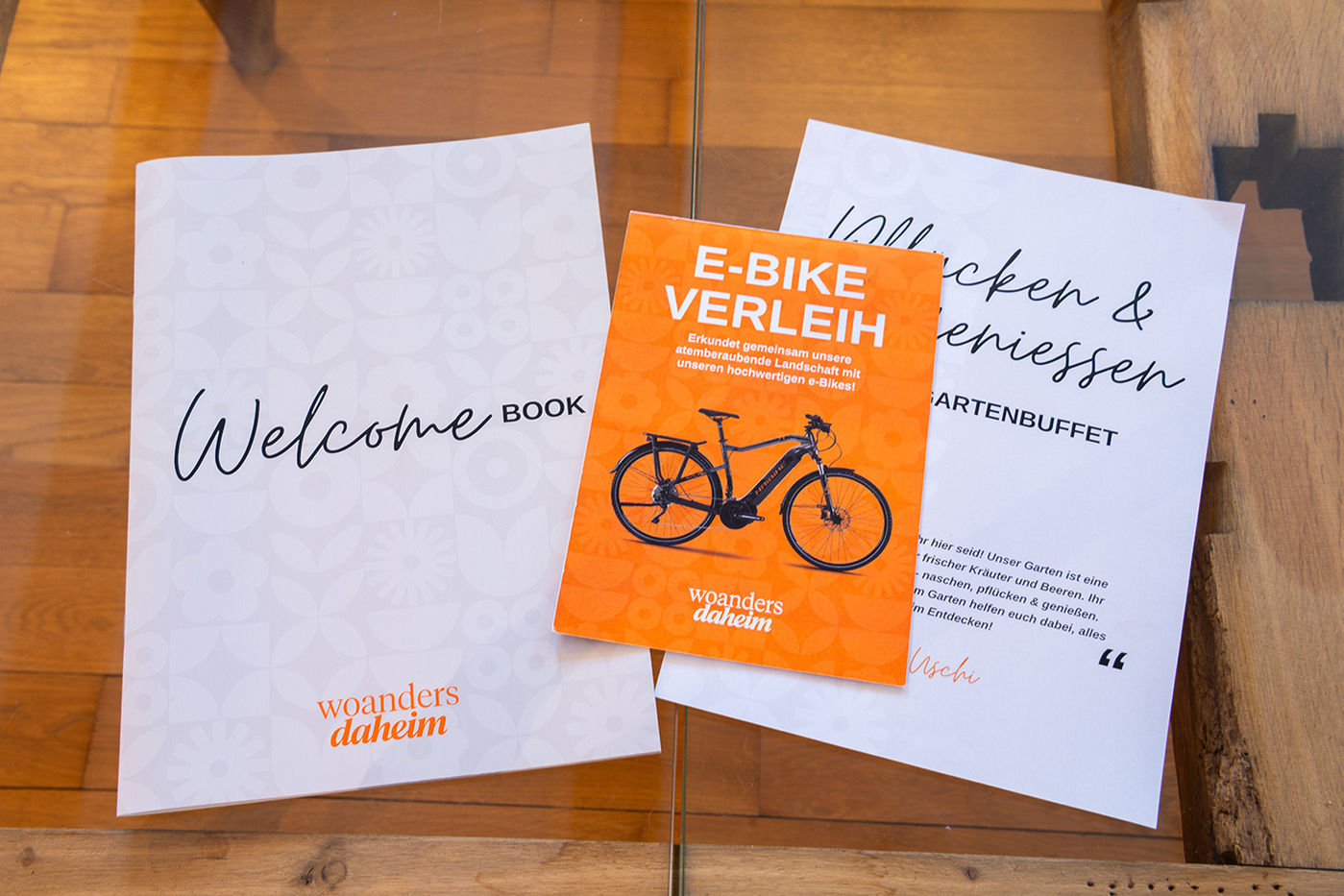 Auf einem Glastisch liegen zwei Flyer und ein Magazin