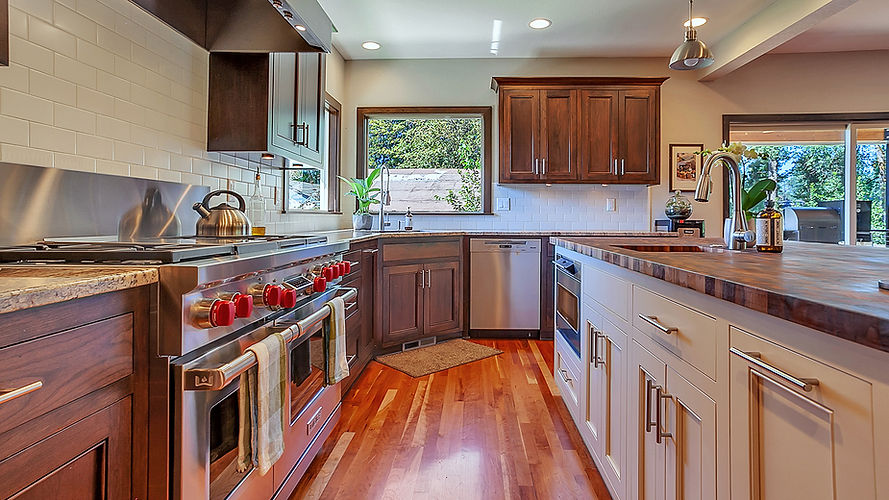 Stain kitchen with butcher block countertop on the island. Wolf appliances. Custom cabinets. Hardwood floors. 