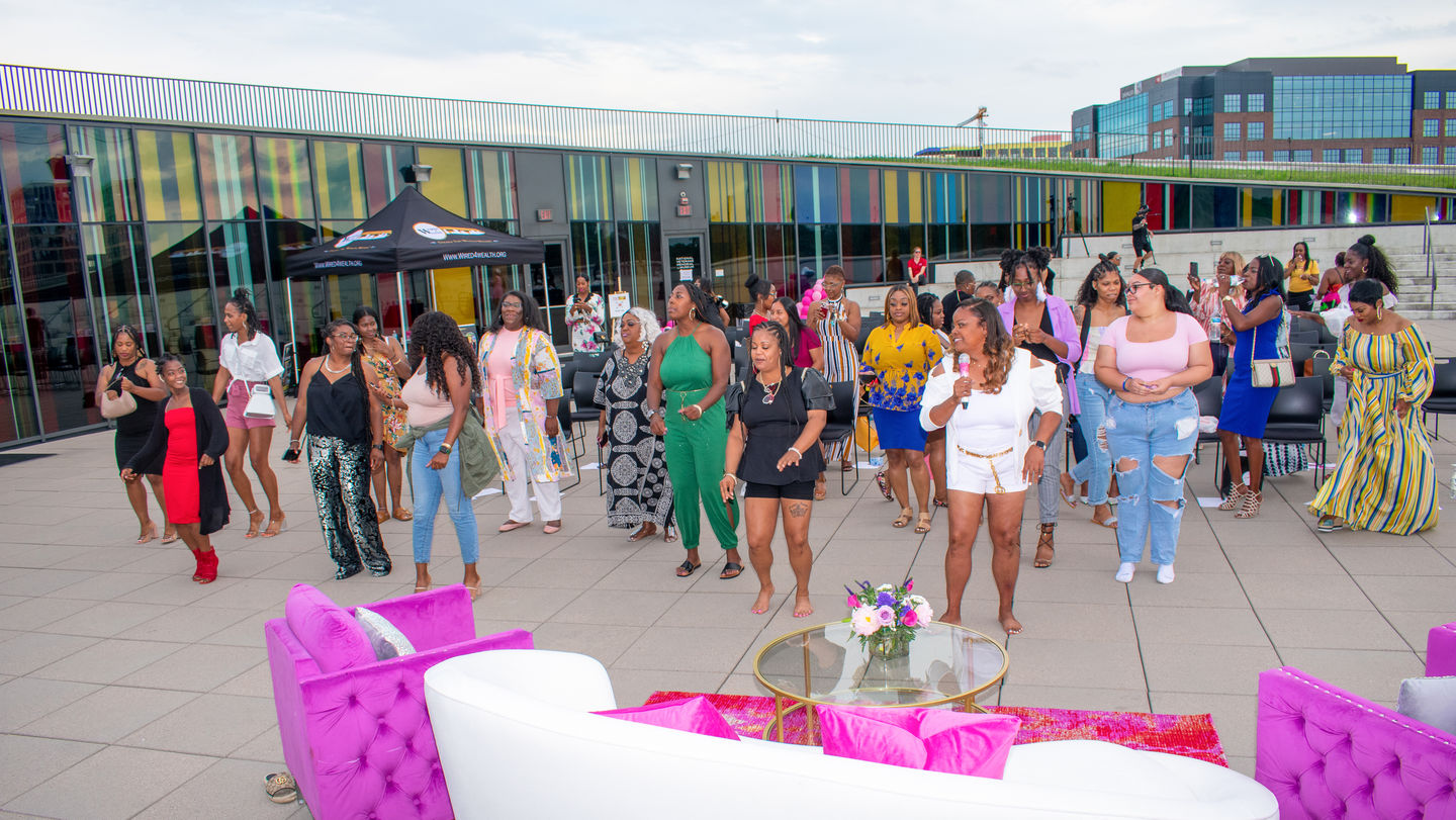 Women singing and dancing outdoors at a summer event