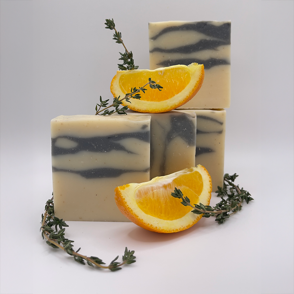 Orange Thyme Bar soap stack with orange wedges and sprigs of fresh thyme