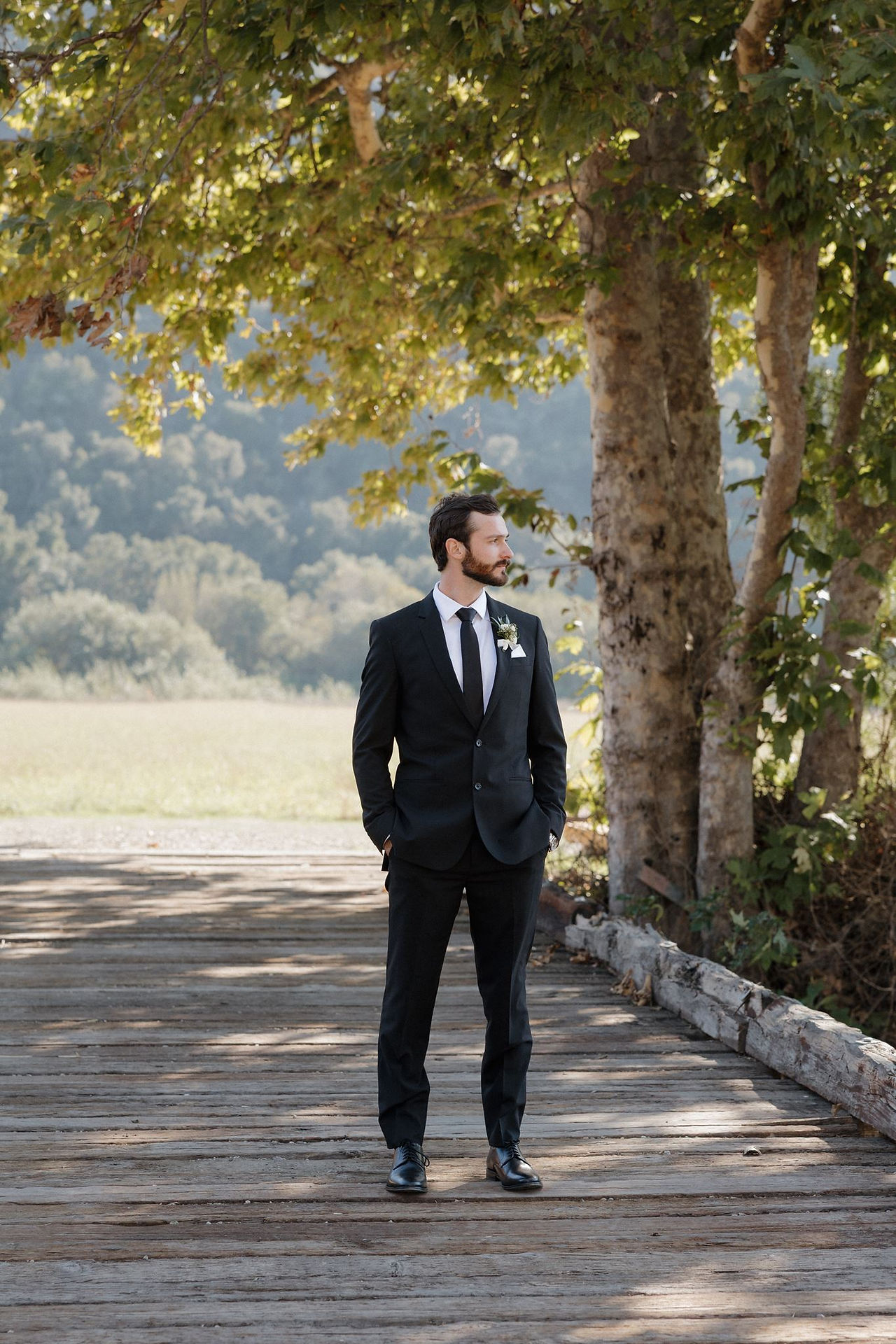 Groom portrait on bridge prior to wedding ceremony at Tar Creek Ranch by SLO Wedding Photographer