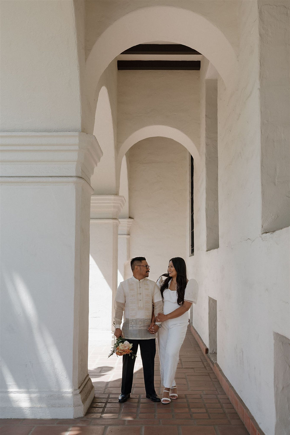 Bride and groom under Santa Barbara Courthouse archways by MacKenzie Rana Photography